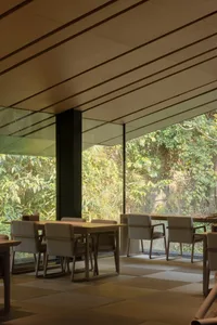 Modern restaurant interior with large windows, dining tables, and comfortable seating for guests