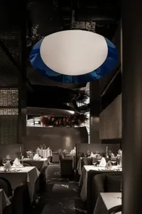 Empty restaurant with wooden tables, chairs, and wine glasses, creating an inviting atmosphere for dining