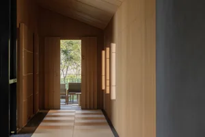 Warm and inviting restaurant interior with wooden walls, a dining table, chairs, and natural light from multiple windows