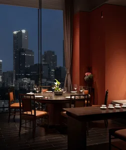 A dining table set with wine glasses and vases in a dimly lit restaurant with red walls and a sophisticated atmosphere