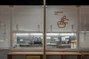 Industrial kitchen with glass doors, bowls, cups, and appliances, featuring a clean and organized atmosphere with a focus on functionality and efficiency