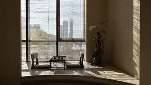 Bright modern living area with a large window, two chairs, and a dining table, featuring a well-lit and functional design