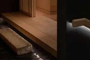 A house with a wooden floor featuring a staircase and two benches, adding warmth and character to the space