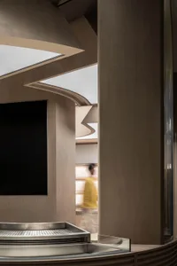 A man walks down a warm and inviting hallway with wooden walls and floors
