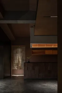 A modern kitchen with wooden floors and walls, featuring potted plants, a vase, and ample storage in a functional design