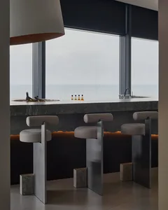 Open kitchen with a countertop island, stools, and natural light from a large window