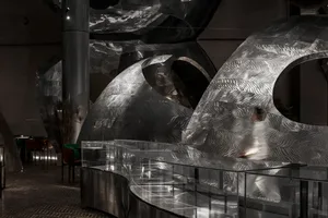 A futuristic interior space with a large dome structure featuring unique metal designs and a modern atmosphere