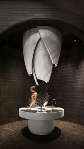 Double sink bathroom with modern fixtures and a woman walking past