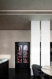 Industrial kitchen with white walls, black appliances, and two large white pillars, exuding a clean and organized atmosphere with a focus on functionality