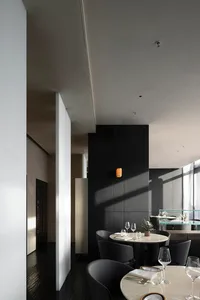 Modern restaurant interior with a dining area, bar, and wine glasses, featuring a sophisticated atmosphere and comfortable seating