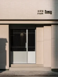 A secure Asian building with a glass door entrance and white brick exterior, conveying a sense of safety and orderliness