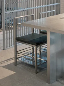 Empty modern kitchen with a stainless steel table and chairs, awaiting occupants or guests