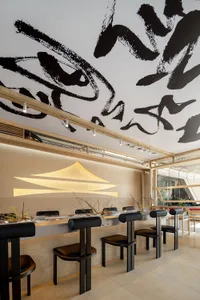 A modern restaurant interior with wooden tables and chairs, creating a warm and inviting atmosphere with numerous dining tables and chairs