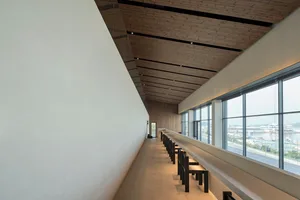 Empty restaurant with wooden walls and ceiling, featuring tables and chairs in a comfortable dining area with an inviting atmosphere