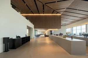 Spacious lobby with wooden walls and ceiling, modern design, wood and concrete elements, chairs, inviting atmosphere
