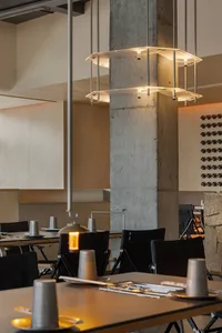 Sleek dining space with concrete walls, wine glasses, and modern furniture