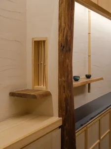 Warm kitchen space with a wooden countertop, two bowls, and a bench, featuring a cozy atmosphere