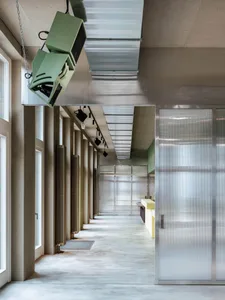 A calm and inviting lobby with a yellow wall, large windows, and concrete walls