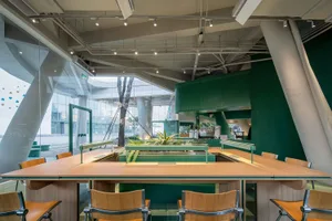 A cozy dining area with a wooden table, metal chairs, and potted plants, perfect for a meal or coffee