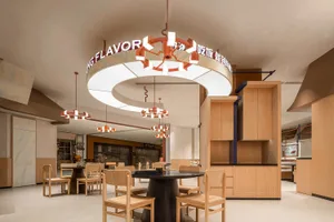 Warm and inviting restaurant interior with wooden tables, chairs, and paneling, dimly lit for a cozy ambiance