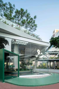 A modern building with a green roof and a large glass wall that allows for natural light and creates a bright and airy atmosphere