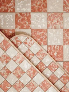 Pink tiled wall with a white border and a checkered pattern of red and white squares in a bathroom or kitchen area