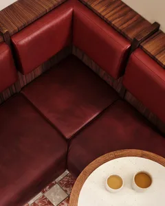 Cozy living area with red leather couches, a dining table, and warm atmosphere