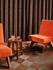 A cozy living area with a fabric chair and wooden table, set up for conversation or relaxation