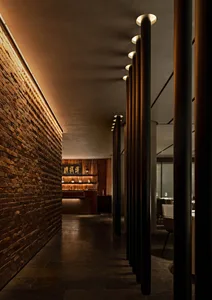 Cozy restaurant interior with a brick wall, wooden elements, and dining tables and chairs