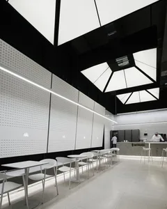 Empty restaurant interior with white walls, dining tables, and comfortable seating arrangement, featuring modern simplicity and well-planned lighting