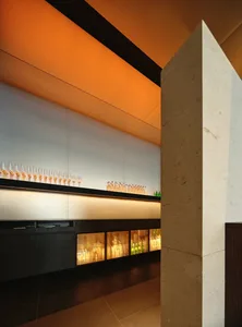 A well-stocked bar area with a long counter featuring numerous bottles and a casual atmosphere
