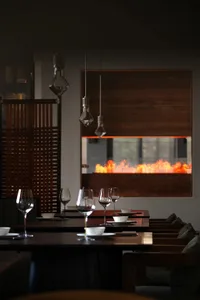 A dining table set for dinner in a warm and inviting restaurant with wooden accents and wine glasses, surrounded by chairs