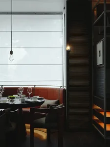 Sophisticated dining area with a large window, multiple chairs, and wine glasses on a dining table