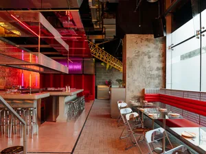 Inviting restaurant space with red walls, wooden furniture, and dining tables, creating a warm atmosphere for socializing and meals