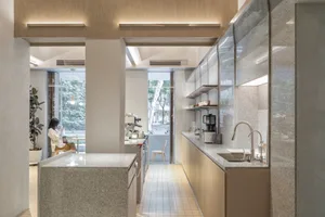 Open kitchen with wooden cabinets, two sinks, and a countertop island, creating a warm and inviting atmosphere for cooking and dining