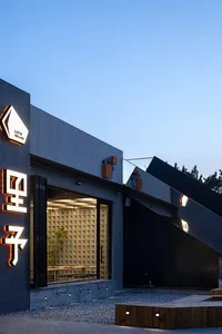 A modern Asian restaurant with black walls, natural light, and dining tables, creating a comfortable atmosphere for guests