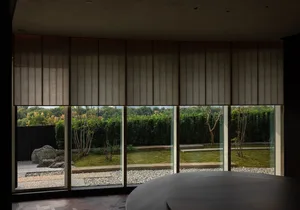 Bright and spacious living area with a modern design, large windows, a sleek dining table, and decorative touches