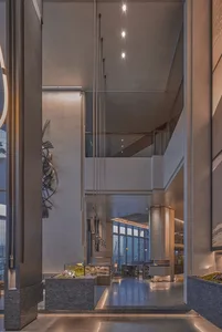 A modern building with concrete walls, large windows, and integrated windows, doors, and staircases, showcasing a spacious and sophisticated interior design