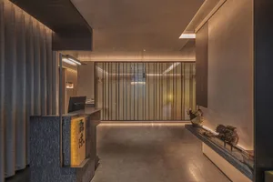 A modern kitchen and dining space with a countertop area, desk, and sink, featuring two sinks and a dining table near the left wall