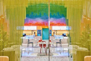 A modern dining area with multiple white tables and chairs, creating a clean and inviting atmosphere for a meal or coffee