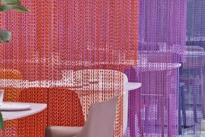 A modern restaurant dining area with a purple and orange color scheme, featuring two chairs and a dining table surrounded by chairs, creating an inviting and comfortable atmosphere