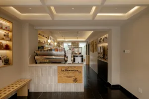 Industrial kitchen with a counter, appliances, and bottles, featuring a functional and well-equipped space for food preparation and storage