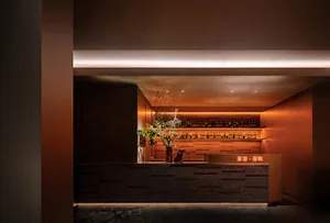 Elegant bar area with a wooden counter, wine glasses, and a vase, creating a sophisticated and inviting atmosphere