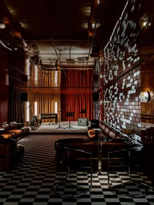 A modern lounge area with a piano, dining table, and chairs, featuring a stylish and elegant atmosphere