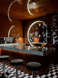 Elegant kitchen with a marble island, stools, wine glasses, and a sink, set in a modern and sophisticated atmosphere