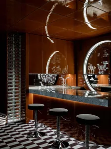 Modern kitchen with a large island, stools, sink, and wine glasses, giving off a sophisticated vibe