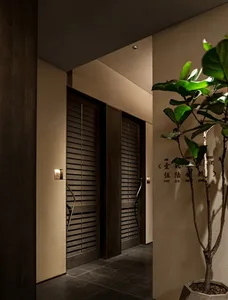 A dimly lit hallway with wooden walls, two doors, and a simple functional style