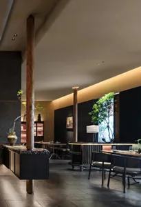 Modern restaurant interior with wooden columns, multiple dining tables, and chairs, creating a sophisticated atmosphere