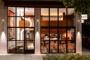 Inviting restaurant interior with dining tables, chairs, and wine glasses, providing a comfortable dining experience