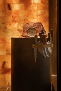 A kitchen scene with knives, a wine glass, and a clock, creating a cozy atmosphere with a functional layout